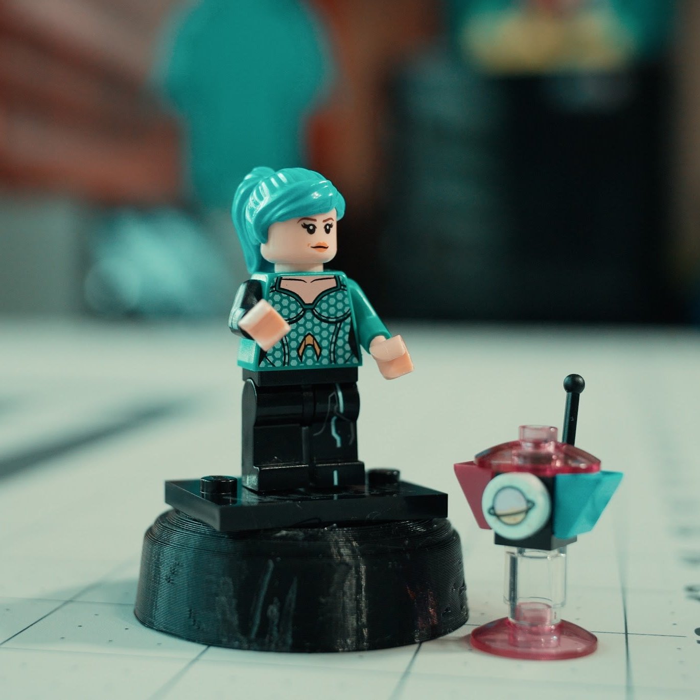 Custom LEGO minifigure of Amie with blue hair, wearing an outfit that matches her look from LEGO Masters.